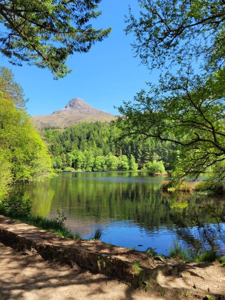 Loch entouré de forêt et de montagnes en Écosse