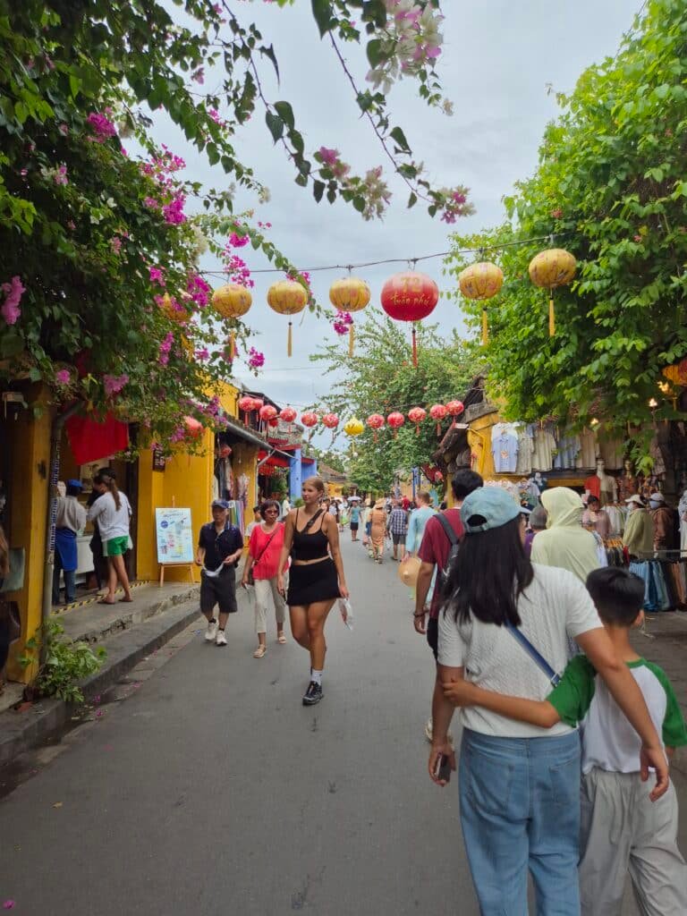 Une mère et son enfant se promènent dans les rues fleuries de Hoi An au Vietnam